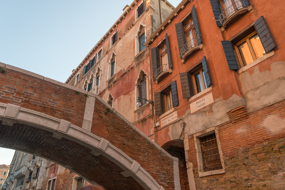 Venedig, Italien, stiller Kanal mit Brücke und roter Hausfassade
